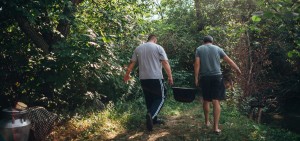 Roman and Arcadie carrying the stew in the cauldron.